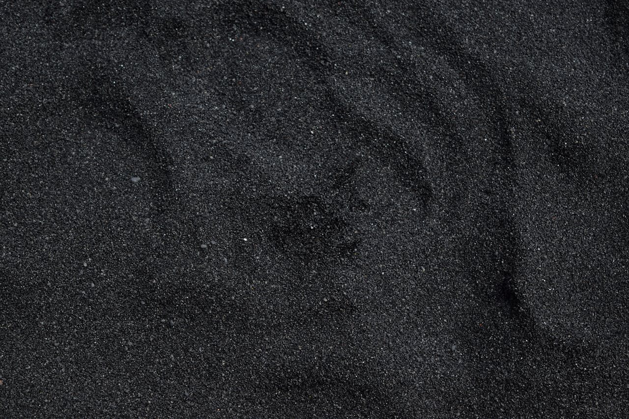 Close-up of black sand texture from Waimea Beach in Hawaii. Ideal for backgrounds.